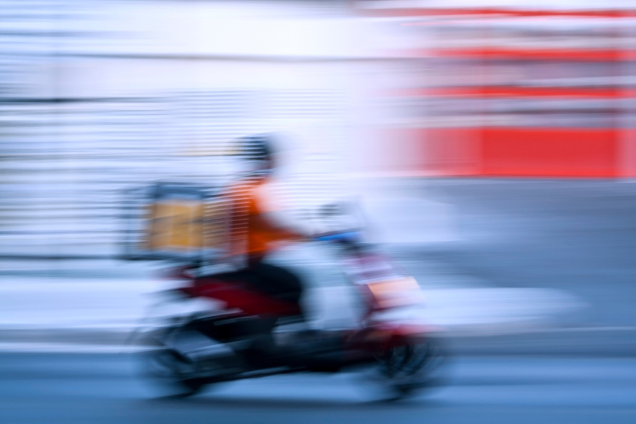 Delivery man on motorbike in motion